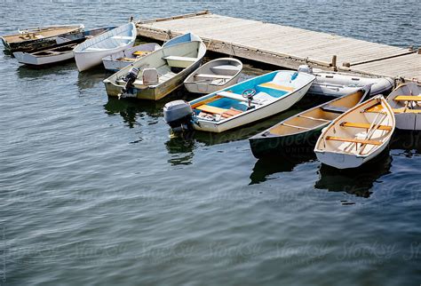 Row Of Small Boats Tied To A Dock In A Harbor By Stocksy Contributor