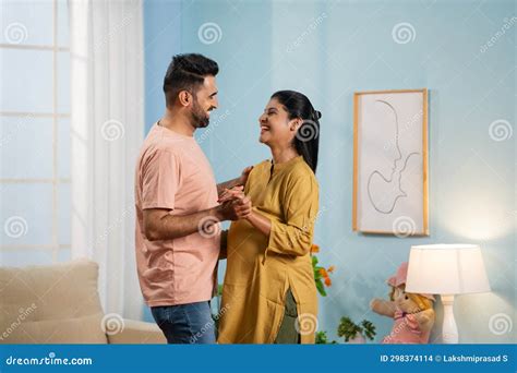 Joyful Indian Pregnant Wife With Husband Doing Romantic Dance At Home