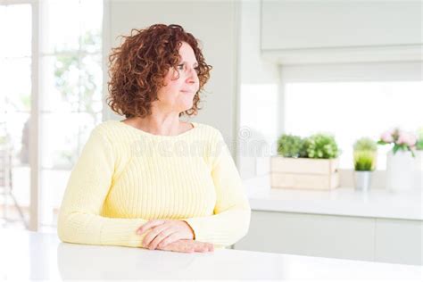 Beautiful Senior Woman Wearing Yellow Sweater Looking To Side Relax