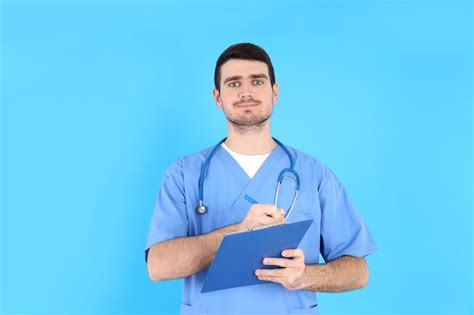 Premium Photo Male Nurse With Clipboard On Blue Background