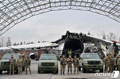 파괴된 안토노프 225 화물기 앞 우크라 병사와 차량