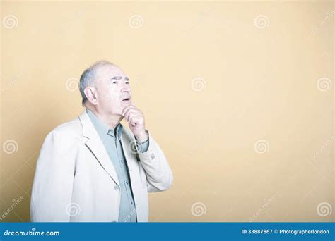 Senior Adult Man With His Hand On His Chin Looking Up Inquisitively