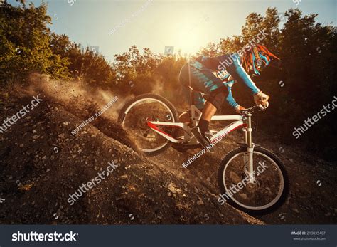 Man Riding A Mountain Bike In Downhill Style At Sunrise Extreme Sports On A Bicycle Stock