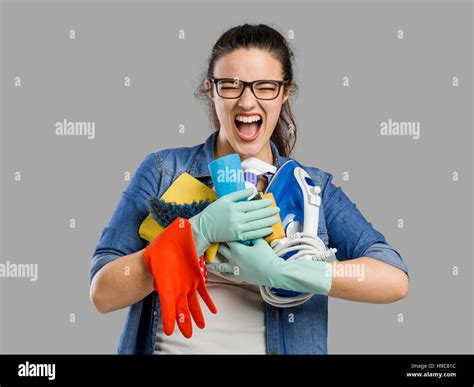 Portrait Of A Tired Woman With Hands Full On Cleaning Stuff Stock Photo