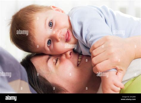 Joyful Mother Cuddling Her Baby Boy With Affection Stock Photo Alamy