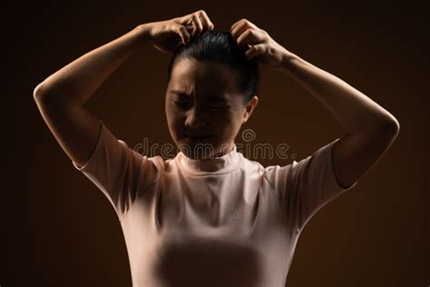 Asian Woman Scratching Her Head Standing Isolated On Beige Background