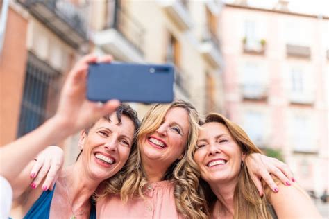 Premium Photo Three Mature Female Friends Hugging Together Taking A Selfie Middle Aged