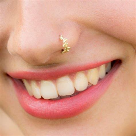 A Close Up Of A Person With A Gold Nose Piercing On Their Left Side Of