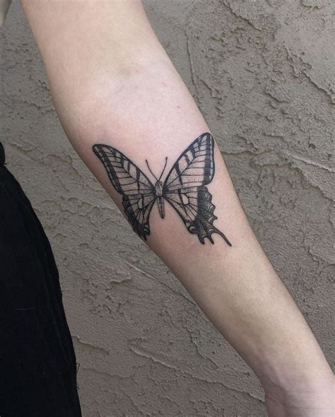 A Black And White Butterfly Tattoo On The Right Arm It Looks Like An