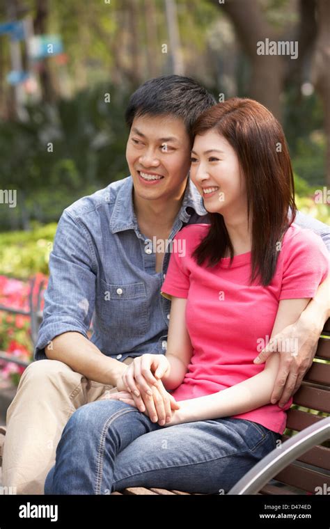 Young Chinese Couple Relaxing On Park Bench Together Stock Photo Alamy