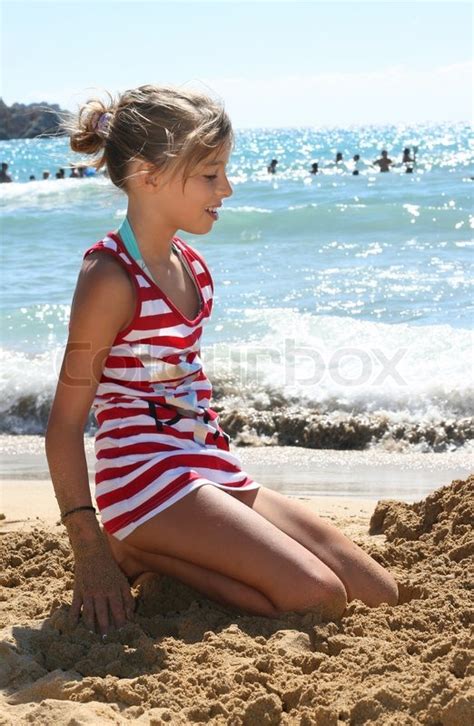 Eine L Chelnde Junge M Dchen Auf Dem Sand Am Meer Stockfoto Colourbox