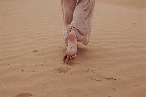 Barefoot Unrecognizable Woman Going Away In Desert By Stocksy