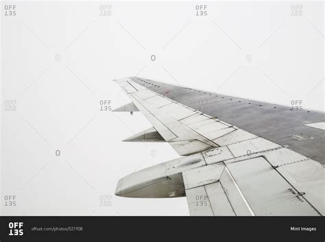 An Airplane Wing In Flight Against A Grey Cloudy Sky Stock Photo Offset
