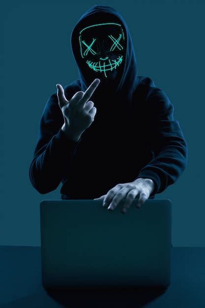 Premium Photo Anonymous Man In A Black Hoodie And Neon Mask Hacking