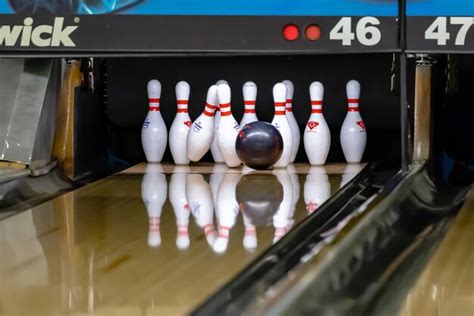 Premium Photo Bowling Ball Hitting Pins At A Bowling Alley