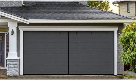 Two Garage Doors With Lights On Them In Front Of A House That Has Gray