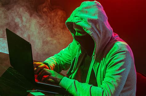 Hooded computer hacker stealing information with laptop - CoolWallet S