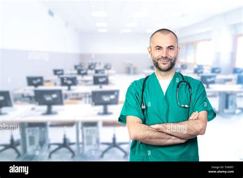 Portraits Of A Smiling Doctor Wearing Green Uniform Arms Crossed And