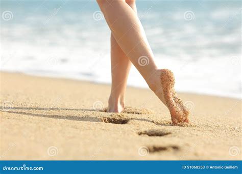 Woman Legs And Feet Walking On The Sand Of The Beach Stock Image