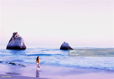 Woman Standing On Beach Facing Ocean Rear View High Res Stock Photo