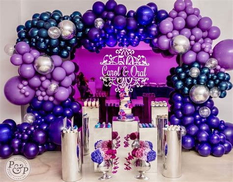 Purple And Blue Balloons Are On Display In Front Of A Table With Silver