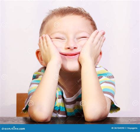 Portrait Of Blond Boy Child Kid Making Funny Face At The Table Stock