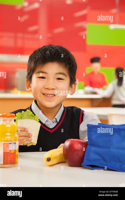 Retrato De Niño Escolar Comer El Almuerzo En La Cafetería De La Escuela