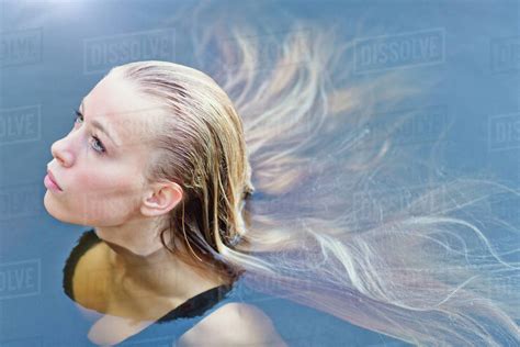 Portrait Beautiful Blonde Teenage Girl With Long Hair Floating In Swimming Pool Stock Photo
