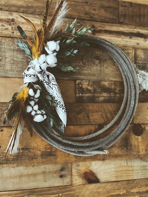 A Wreath Made Out Of Rope And Feathers On Top Of A Wooden Wall With