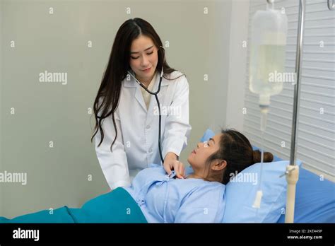 Smiling Asian Female Doctor Using Stethoscope Listening Checking Heartbeat Fat Woman Patient On