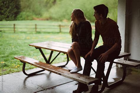 Boy And Girl Sitting On A Picnic Bench Out Of The Rain By Gabrielle
