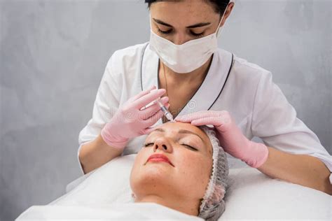The Doctor Cosmetologist Makes The Facial Injections Procedure Stock