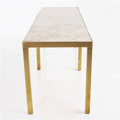 This elegant wood table features a stunning scalloped marble table top and detailed table legs in a rich antique white finish. Narrow rectangular brass and marble coffee table by Edward ...