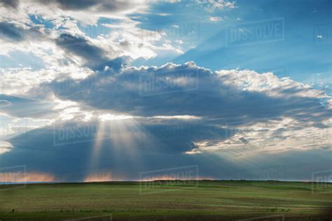 Sunrays Shining Through Clouds Over Field Stock Photo Dissolve