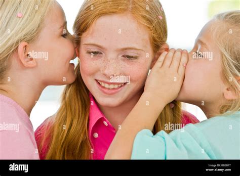 Two Girls Whispering To Another Girl Stock Photo Alamy