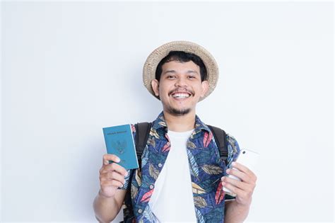 A Young Asian Backpacker Holding An Indonesian Passport And A