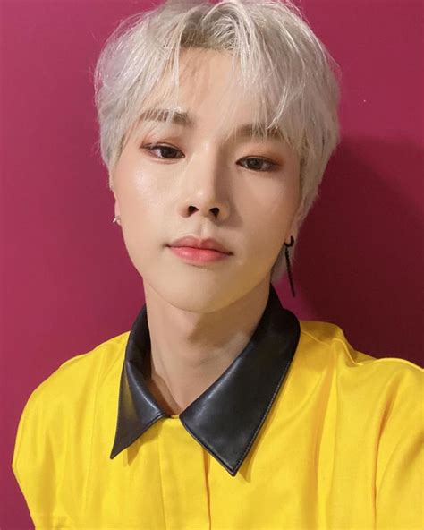 a person with white hair wearing a yellow shirt