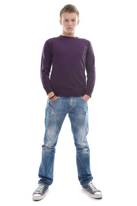 Young Man Standing On White Background With His Hands In His Pockets