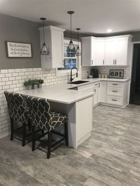 Black and white will forever be a winning combo. White shaker cabinets with solid surface countertops and ...