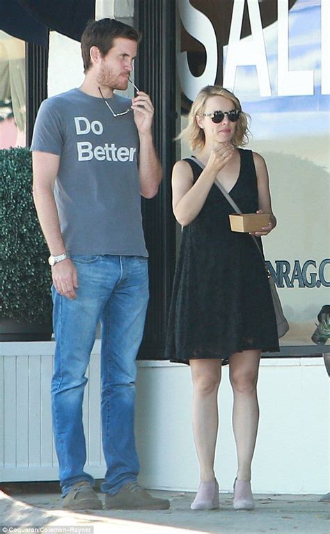 A Man Standing Next To A Woman In Front Of A Store Window Talking On A Cell Phone