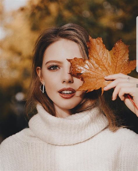 A Woman Holding A Leaf In Front Of Her Face With The Caption Autumn Is