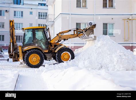 Snow Removal Equipment On The Road In Winter Yellow Excavator Removes