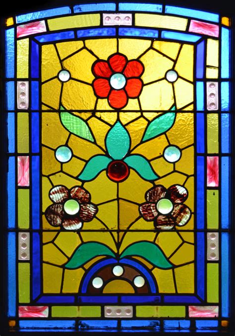 Small pieces of glass are arranged to form patterns or pictures. Window film, stained glass pattern, flowers, yellow, blue
