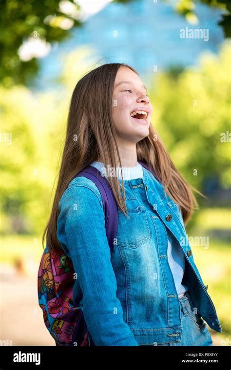 Beautiful Schoolgirl Girl Summer In Nature Dressed In Jeans Clothes Behind Her Backpack