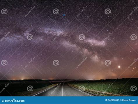 Magenta Night Starry Sky Above Country Asphalt Road In Countryside And