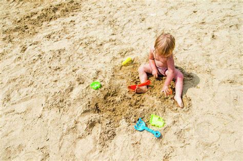 Caucasian Girl Playing In Sand On Beach Stock Photo Dissolve
