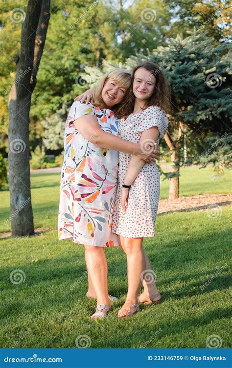 Female Portrait Of A Beautiful Plus Size Blond Blue Eyed Mother And Daughter In The Park During