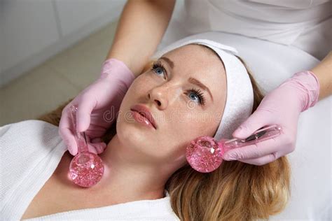 Young Woman Receiving Facial Massage With Glass Balls In Beauty Salon