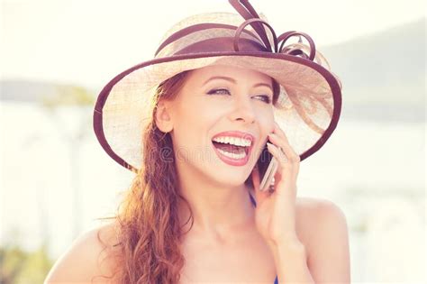 portrait of happy excited laughing beautiful woman talking on mobile phone outdoors in park