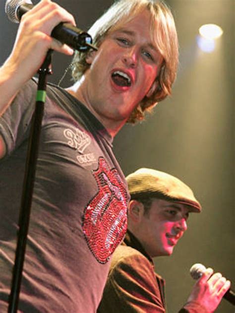 Two Men Singing Into Microphones On Stage